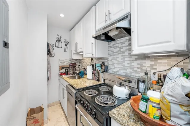 a kitchen with stainless steel appliances granite countertop a stove and a wooden cabinets