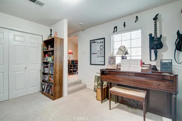 a view of a livingroom with fridge workspace and a window