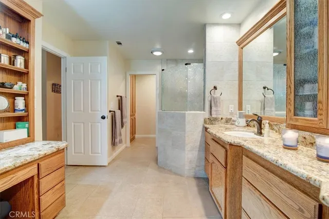 a spacious bathroom with a granite countertop sink and a mirror