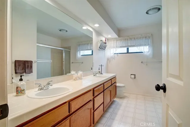 a bathroom with a granite countertop sink a mirror a bathtub and shower