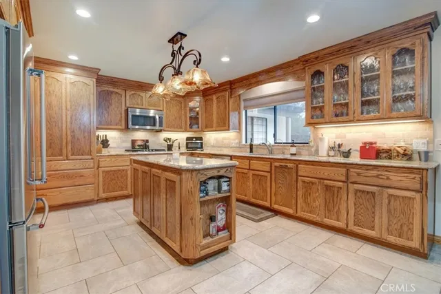 a kitchen with stainless steel appliances granite countertop a sink a stove and a refrigerator