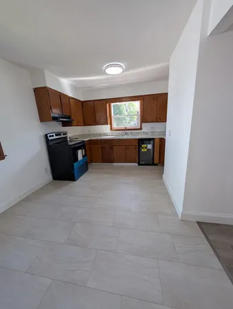an empty room with wooden floor and window