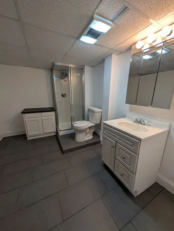 a spacious bathroom with a toilet and a mirror