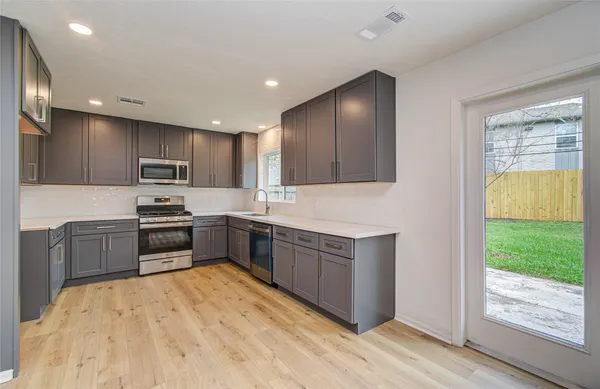 a kitchen with granite countertop stainless steel appliances and wooden cabinets