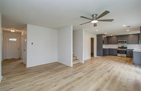 a view of a kitchen with kitchen island wooden floor and a ceiling fan