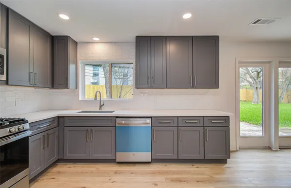 a kitchen with a sink cabinets and window
