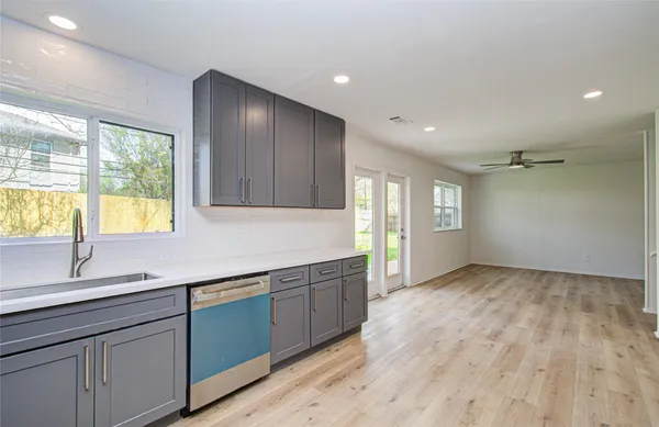 a view of empty room with wooden floor and cabinets