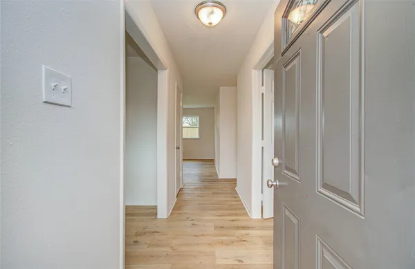a view of a hallway with wooden floor