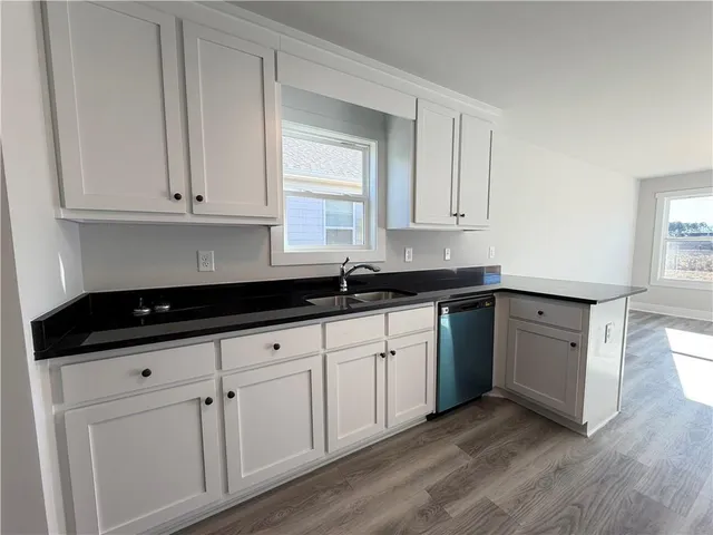 a kitchen with granite countertop white cabinets and sink