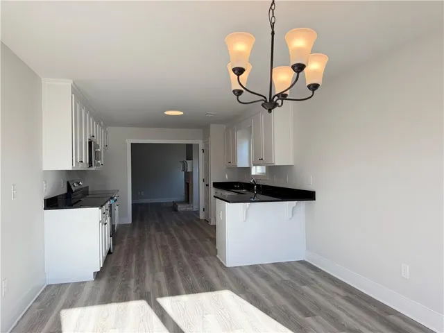a kitchen with cabinets a island stainless steel appliances and wooden floor