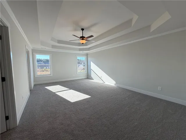 an empty room with windows and ceiling fan