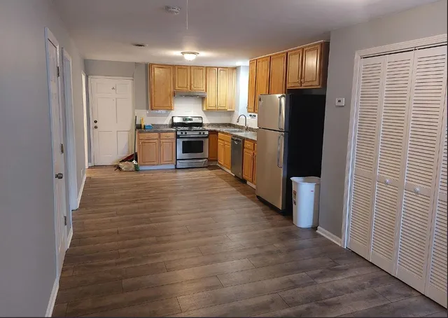 a kitchen with stainless steel appliances a refrigerator and a stove top oven