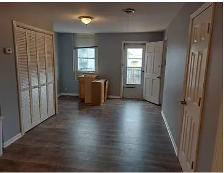 a view of a room with wooden floor and windows