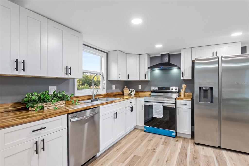 6455 West Cardinal Street Homosassa, FL 34446 - Photo 22 of 38 a kitchen with a white cabinets and stainless steel appliances