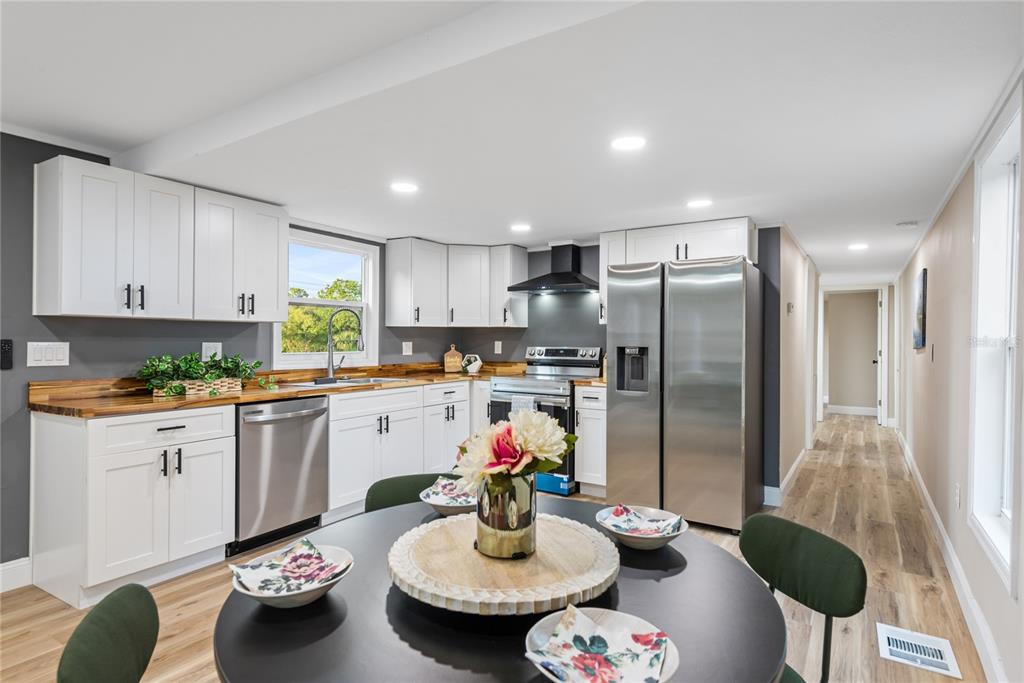 6455 West Cardinal Street Homosassa, FL 34446 - Photo 23 of 38 a kitchen with stainless steel appliances granite countertop a refrigerator and a dining table