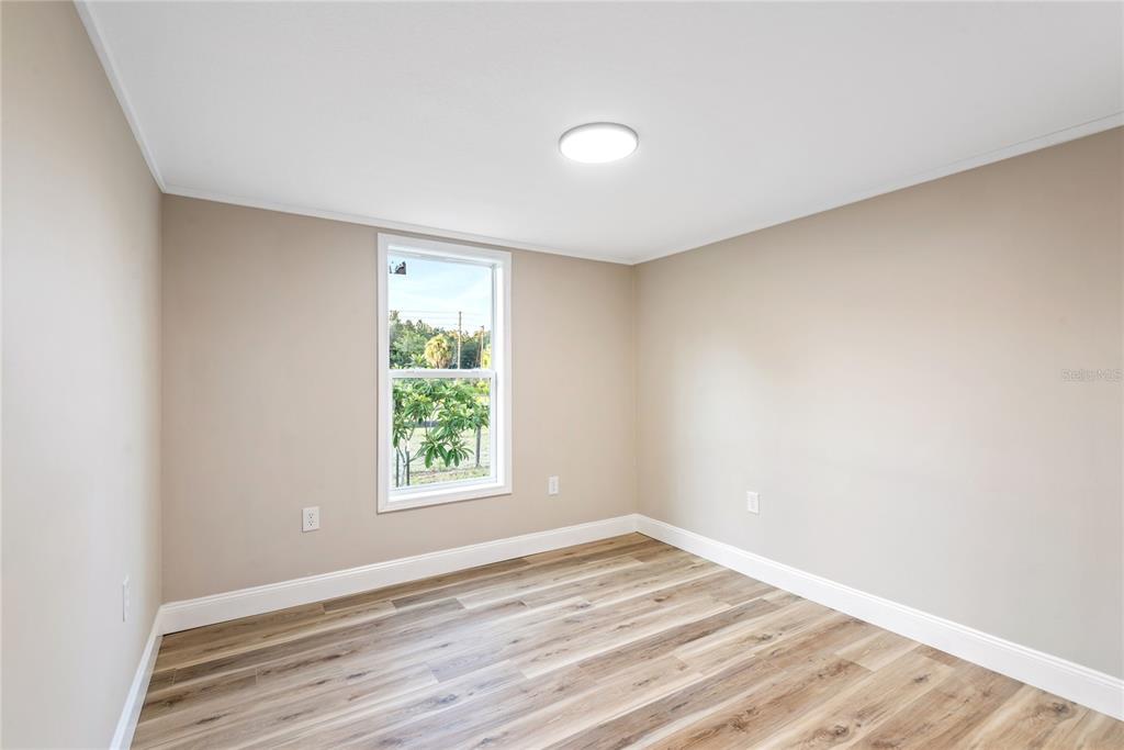 6455 West Cardinal Street Homosassa, FL 34446 - Photo 29 of 38 an empty room with wooden floor and windows