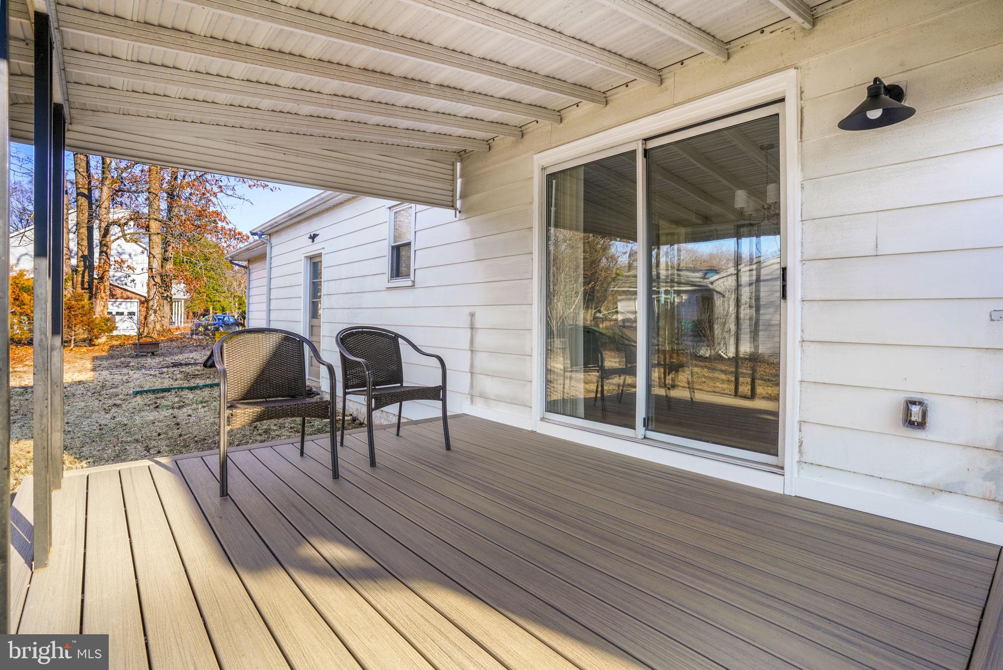 1420 Gilbert Road Arnold, MD 21012 - Photo 21 of 23 a view of a patio with table and chairs under an umbrella with wooden floor
