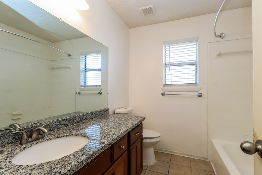13411 Reads Court Houston, TX 77015 - Photo 15 of 16 a bathroom with a granite countertop sink and a mirror