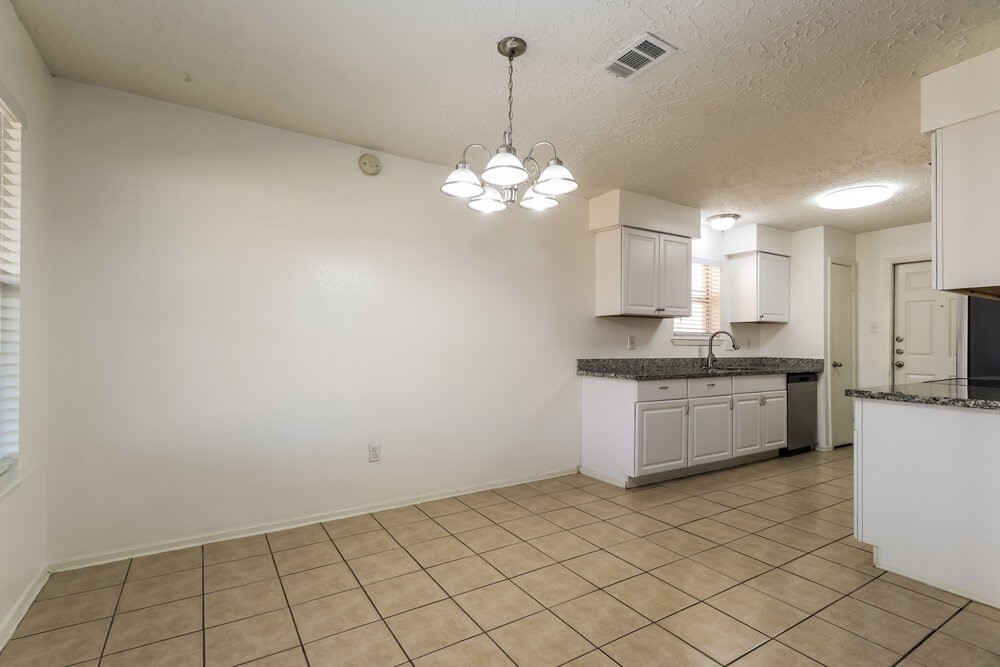 13411 Reads Court Houston, TX 77015 - Photo 6 of 16 a kitchen with granite countertop white cabinets and white appliances