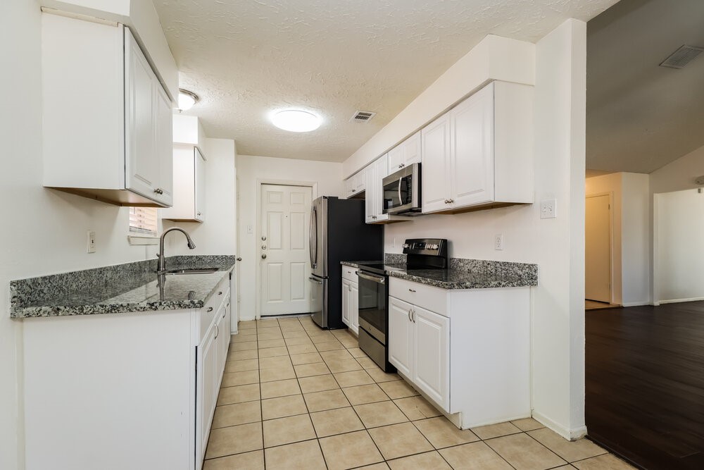 13411 Reads Court Houston, TX 77015 - Photo 7 of 16 a kitchen with stainless steel appliances granite countertop a sink stove refrigerator and cabinets