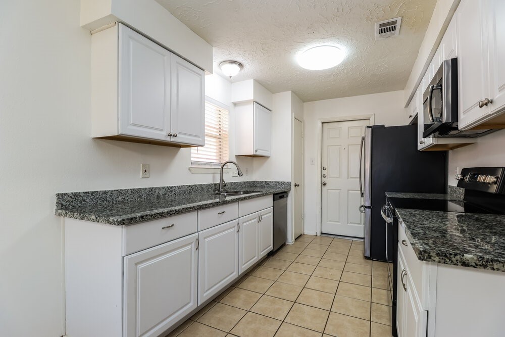 13411 Reads Court Houston, TX 77015 - Photo 8 of 16 a kitchen with stainless steel appliances granite countertop a sink stove and refrigerator