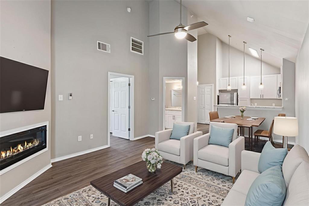 6108 Abrams Road, Unit 521 Dallas, TX 75231 - Photo 8 of 20 Open-concept living area featuring high vaulted ceilings and wood-finish flooring