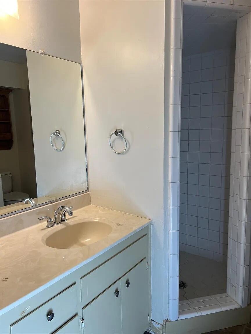 3013 22nd Street Lubbock, TX 79410 - Photo 6 of 9 a bathroom with a granite countertop sink and a mirror