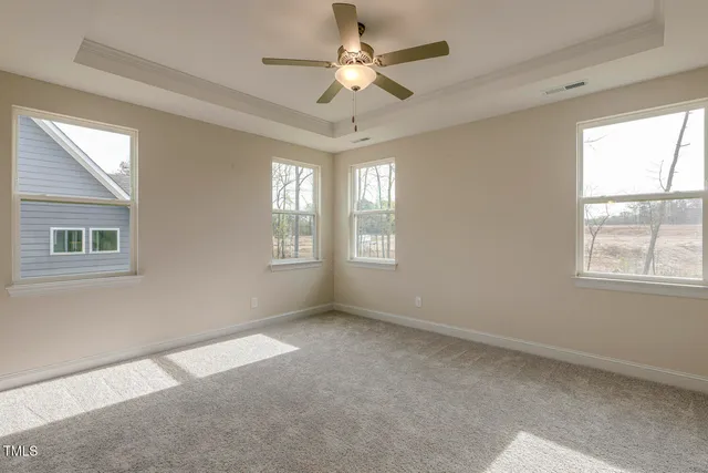 a view of empty room with window and chandelier fan