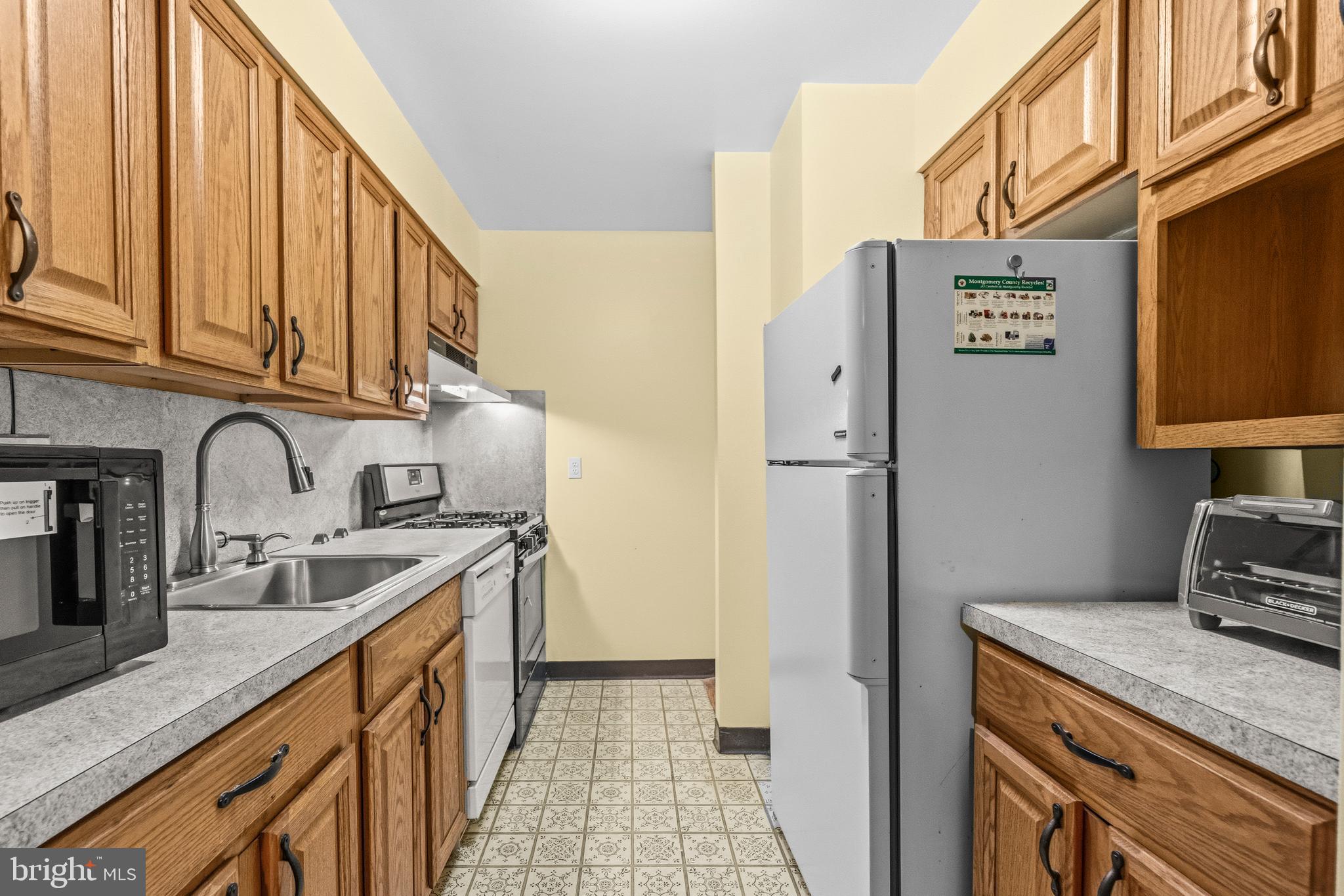 2305 Greenery Lane, Unit T23 Silver Spring, MD 20906 - Photo 11 of 40 a kitchen with stainless steel appliances granite countertop a sink and a refrigerator