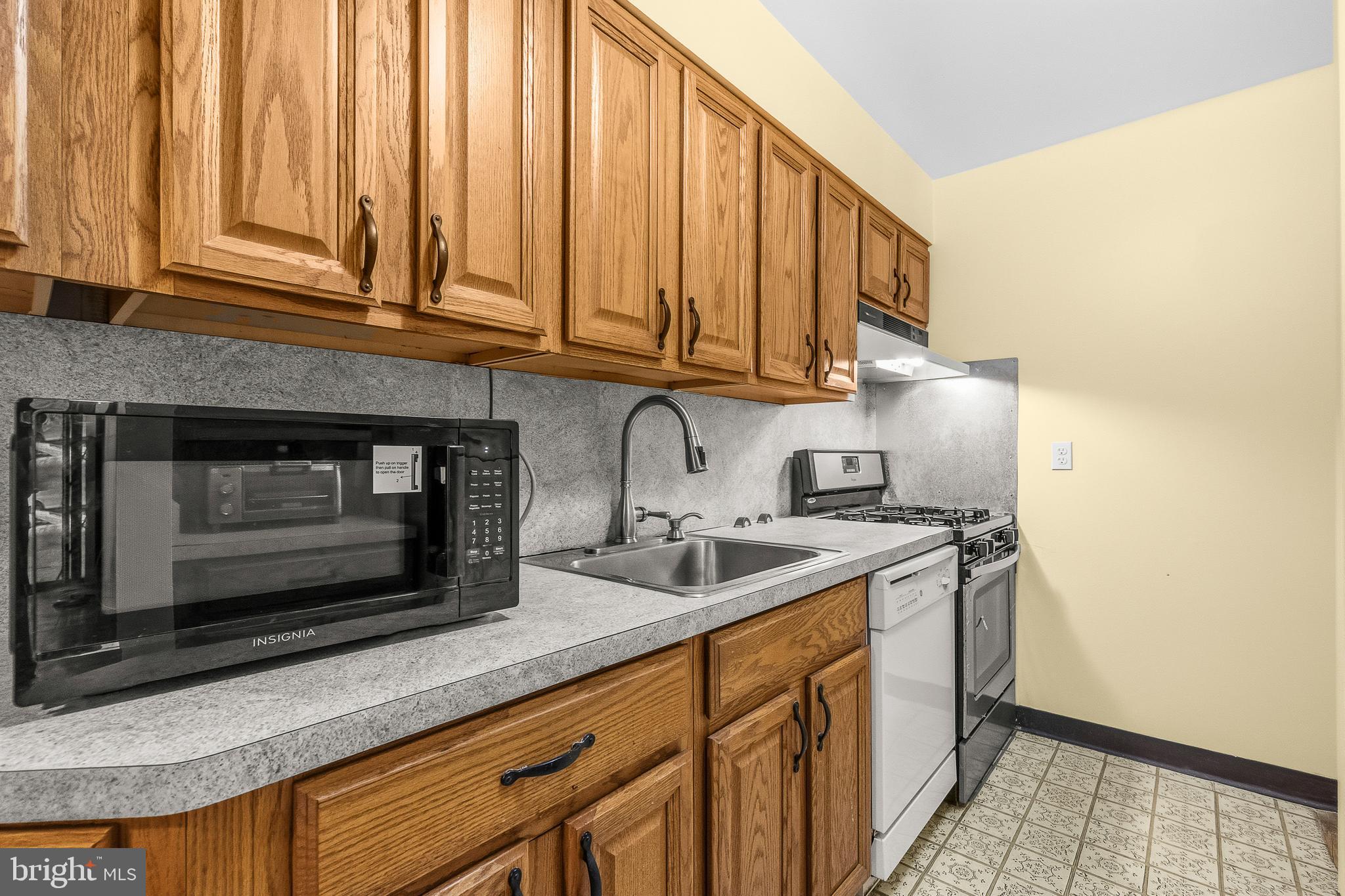 2305 Greenery Lane, Unit T23 Silver Spring, MD 20906 - Photo 12 of 40 a kitchen with stainless steel appliances granite countertop a sink a stove and a microwave