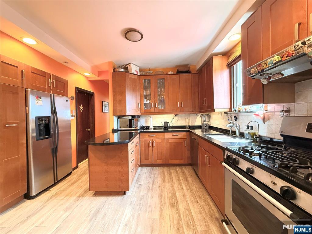 799 2nd Street Secaucus, NJ 07094 - Photo 27 of 48 a kitchen with stainless steel appliances a refrigerator a sink and wooden cabinets
