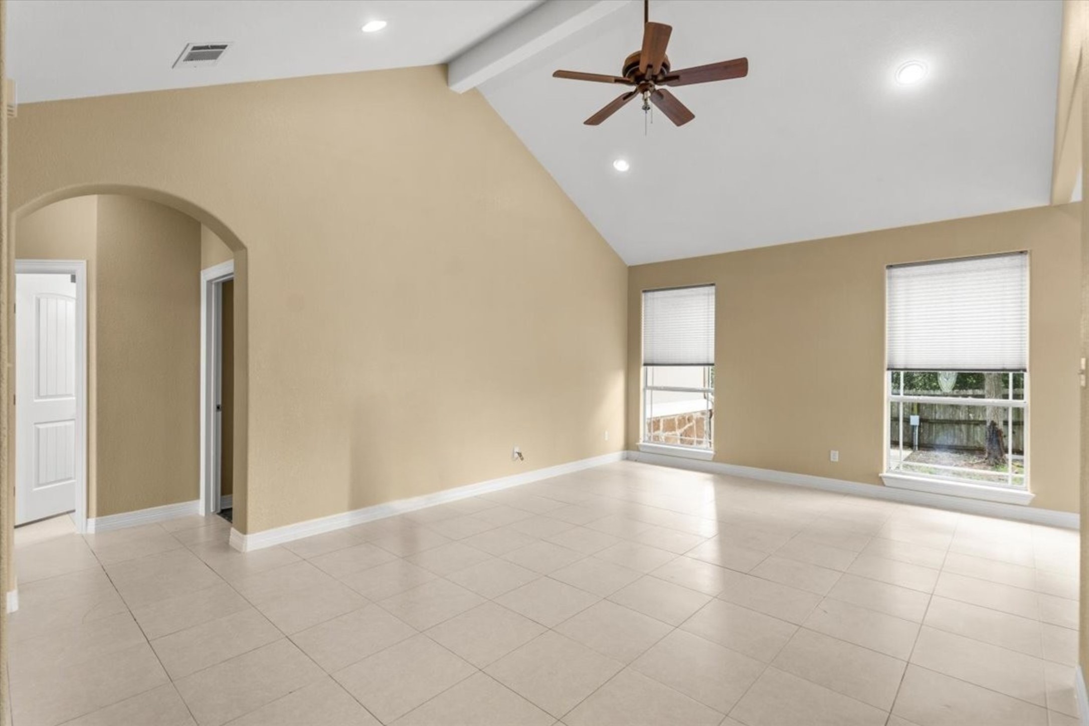 437 Balch Road Elgin, TX 78621 - Photo 4 of 37 Vast tile flooring leads to a spacious living area crowned by a vaulted ceiling and modern ceiling fan.