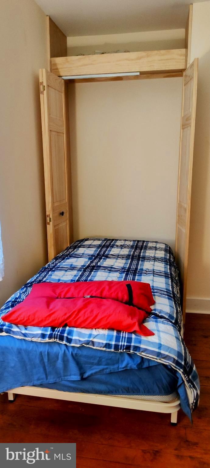 24171 Adelaide Street Parksley, VA 23421 - Photo 13 of 40 a bedroom with a bed and a mirror