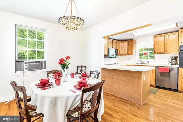 a dining hall with granite countertop a stove a sink and a dining table