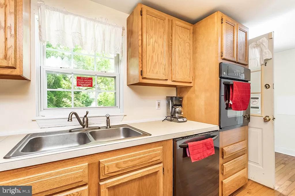 24171 Adelaide Street Parksley, VA 23421 - Photo 25 of 40 a kitchen with stainless steel appliances granite countertop a sink dishwasher and cabinets with wooden floor