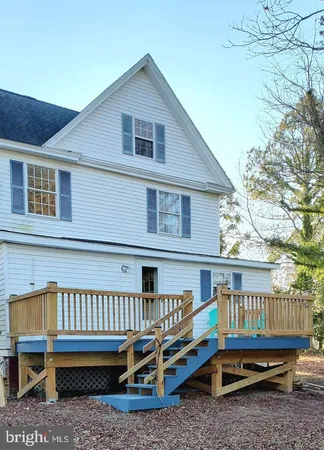 a view of a house with a yard and deck