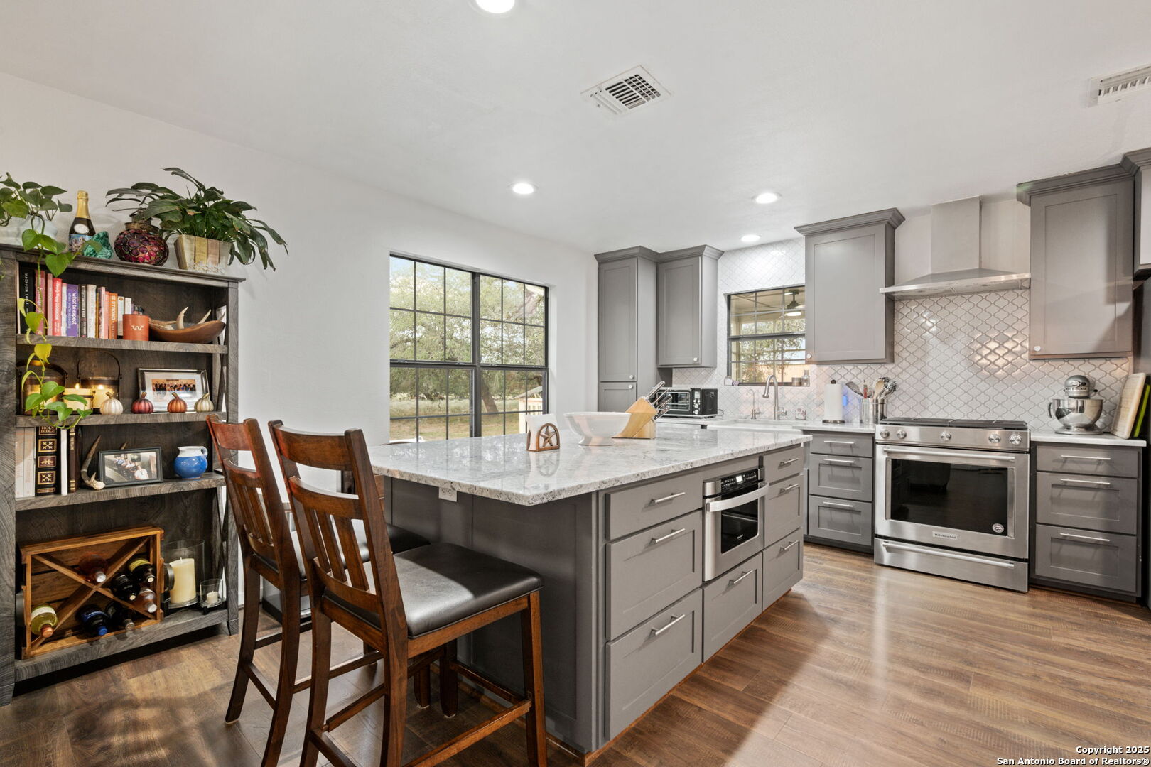 2605 Schuttig Road Pleasanton, TX 78064 - Photo 7 of 35 a kitchen with stainless steel appliances granite countertop a stove top oven a sink a dining table and chairs with wooden floor