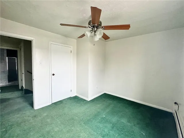 an empty room with closet and fan