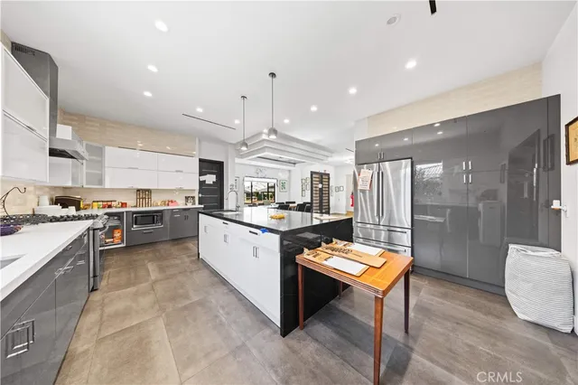 a kitchen with stainless steel appliances kitchen island granite countertop a sink and a refrigerator