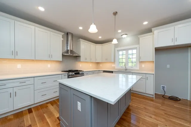 a kitchen with kitchen island a sink stainless steel appliances and cabinets