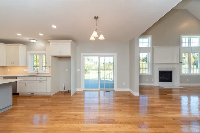 a view of empty room with wooden floor and fireplace