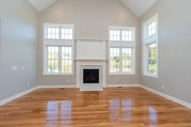 wooden floor fireplace and windows in an empty room