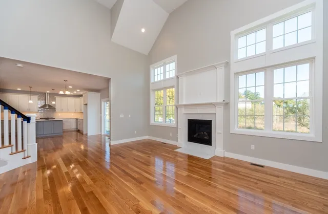 a view of a livingroom with wooden floor and a fireplace