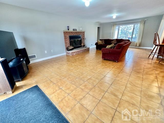 166 Lloyd Road Aberdeen, NJ 07747 - Photo 17 of 56 a living room with furniture a fireplace and a flat screen tv