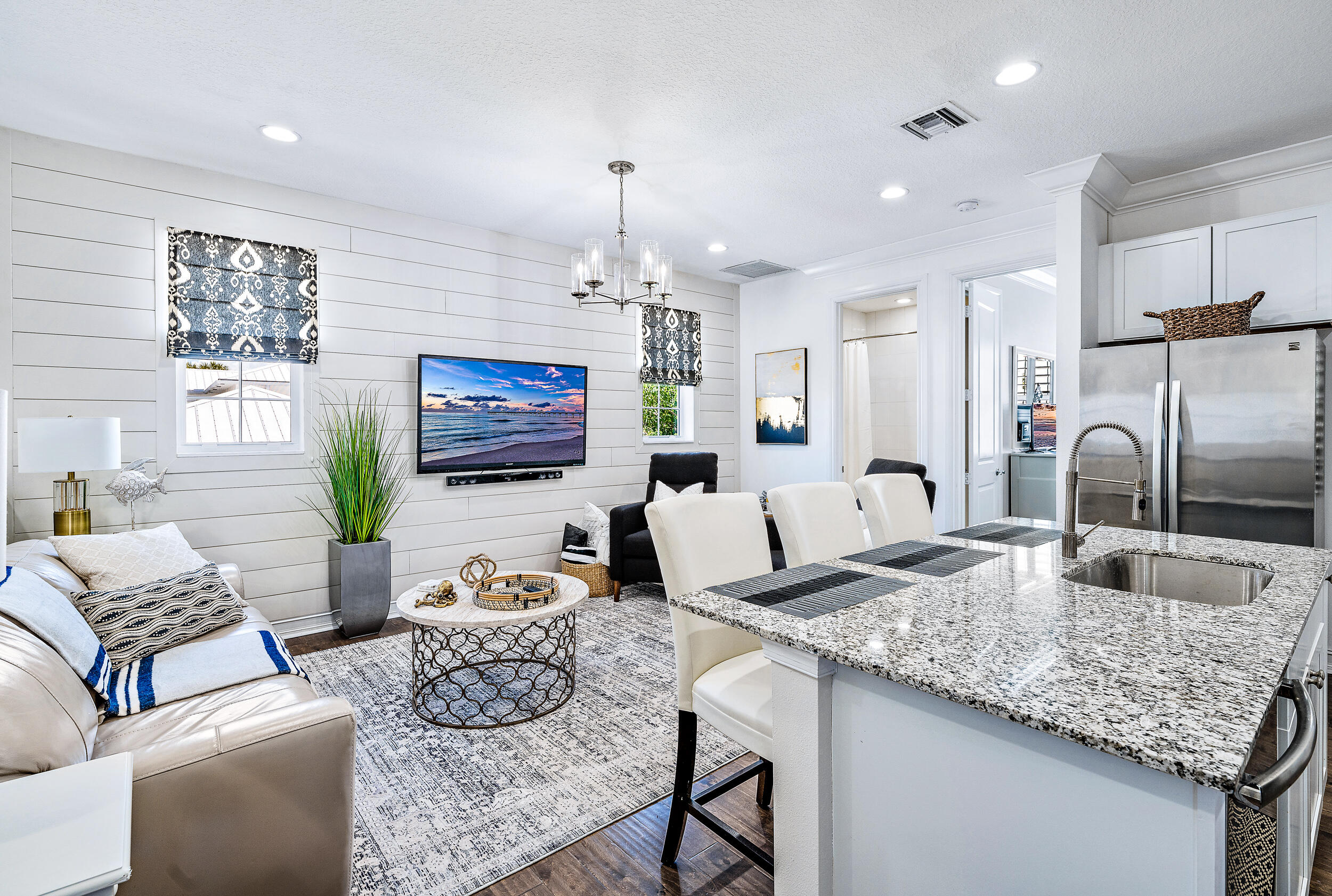 148 Botanica Drive, Unit ADU) Jupiter, FL 33458 - Photo 2 of 14 a living room with kitchen island furniture and a chandelier