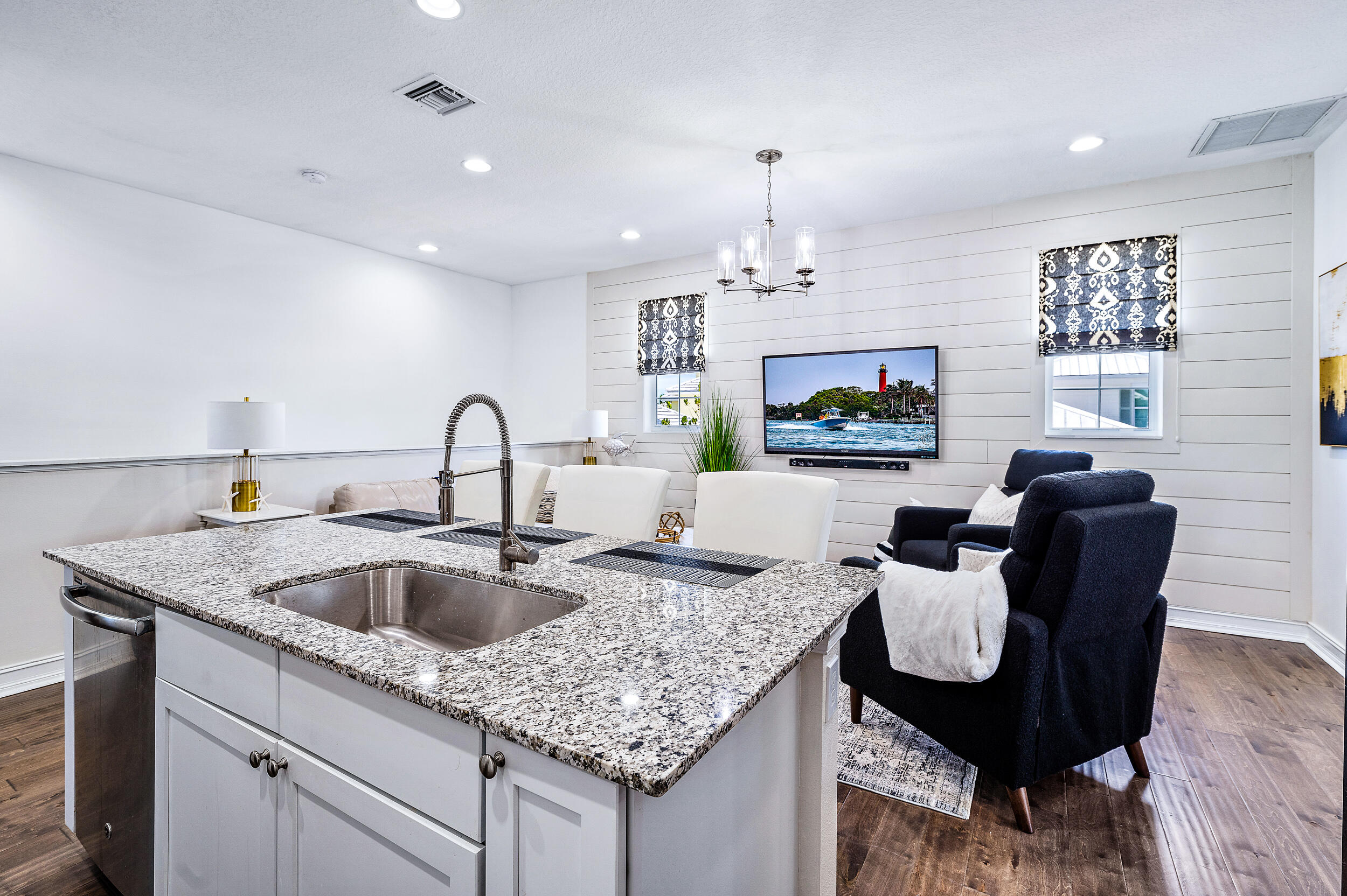 148 Botanica Drive, Unit ADU) Jupiter, FL 33458 - Photo 6 of 14 a kitchen with a granite countertop kitchen island a sink table and chairs