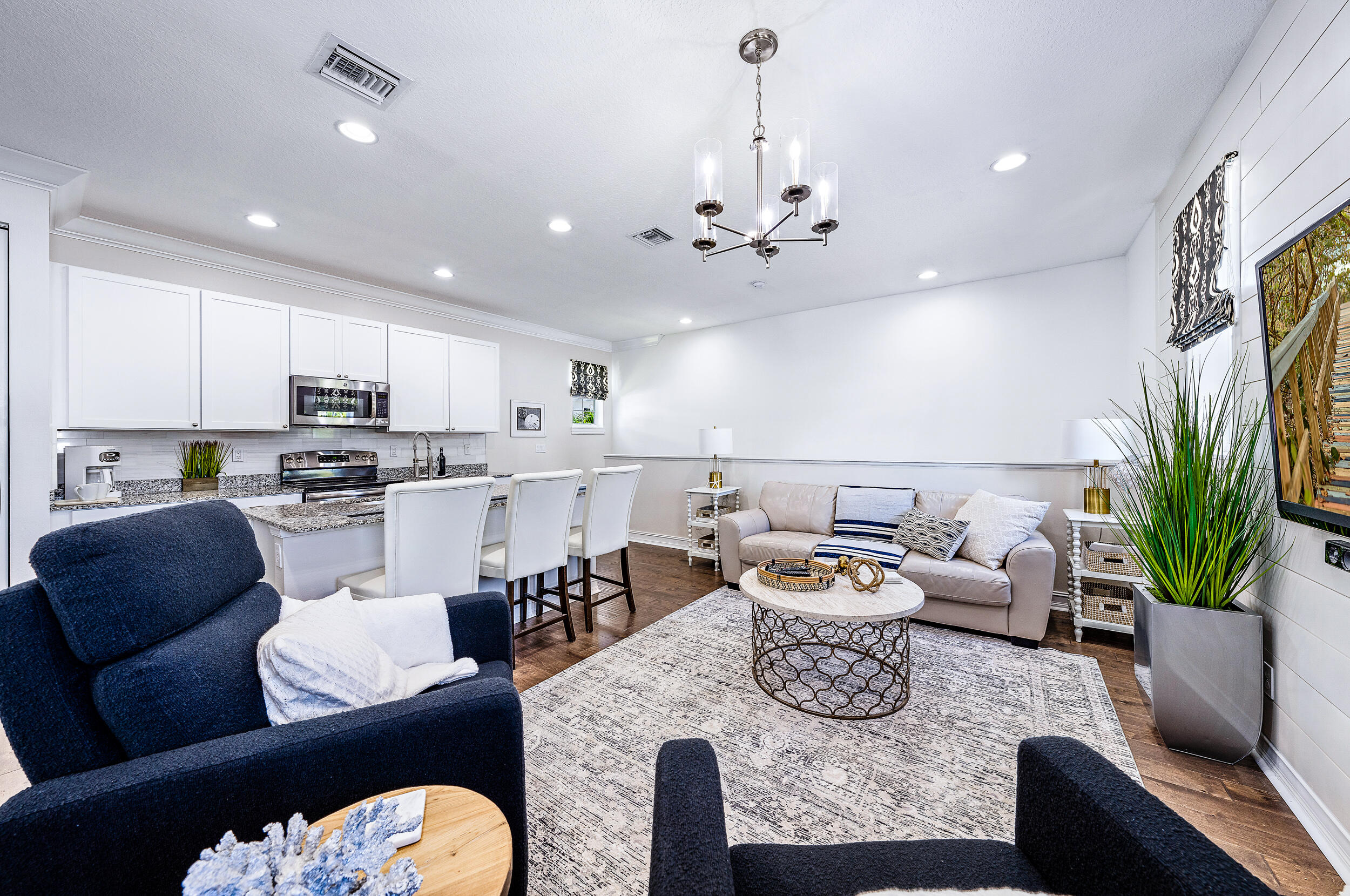 148 Botanica Drive, Unit ADU) Jupiter, FL 33458 - Photo 8 of 14 a living room with furniture kitchen view and a chandelier