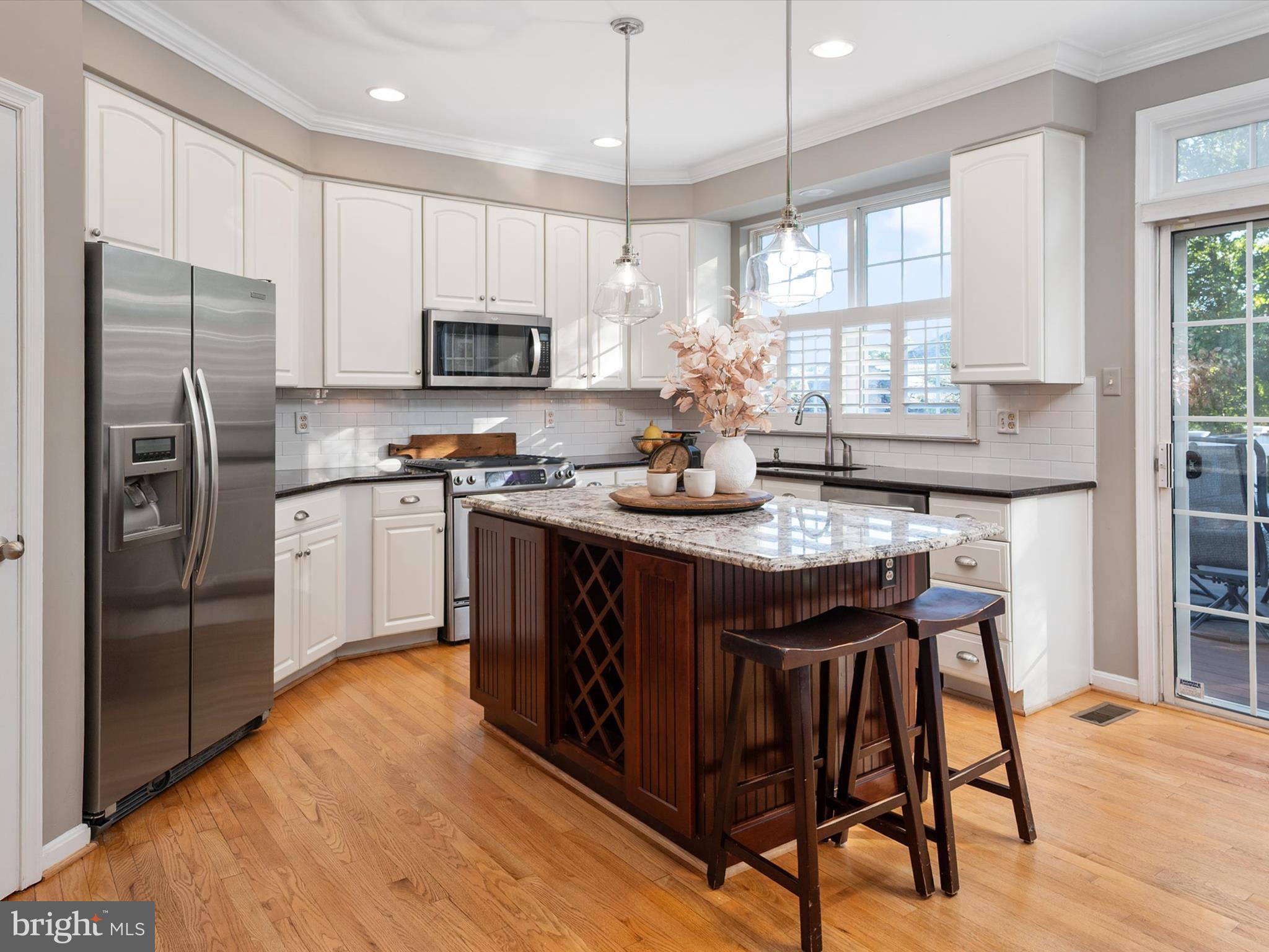 6209 Gatepost Way Elkridge, MD 21075 - Photo 21 of 74 a kitchen with stainless steel appliances granite countertop a table chairs refrigerator and microwave