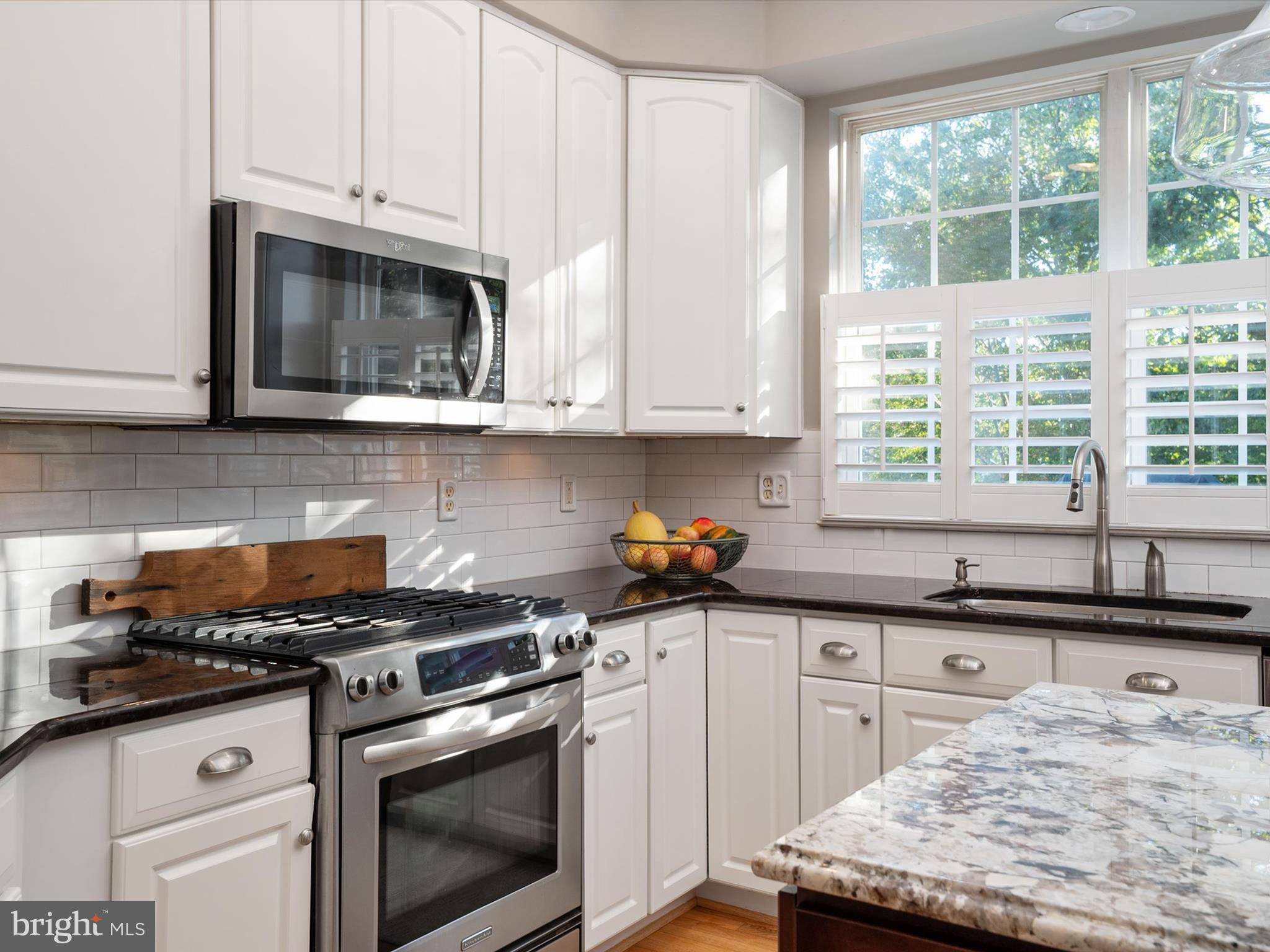 6209 Gatepost Way Elkridge, MD 21075 - Photo 23 of 74 a kitchen with granite countertop a stove a sink and a microwave