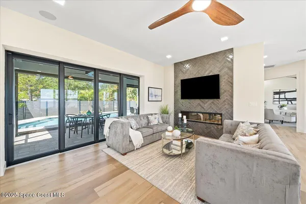 a living room with furniture a flat screen tv and a floor to ceiling window
